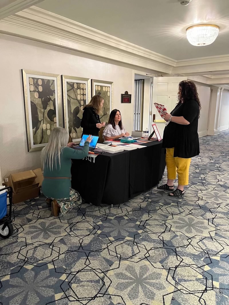 Four people standing around a registration and check-in table