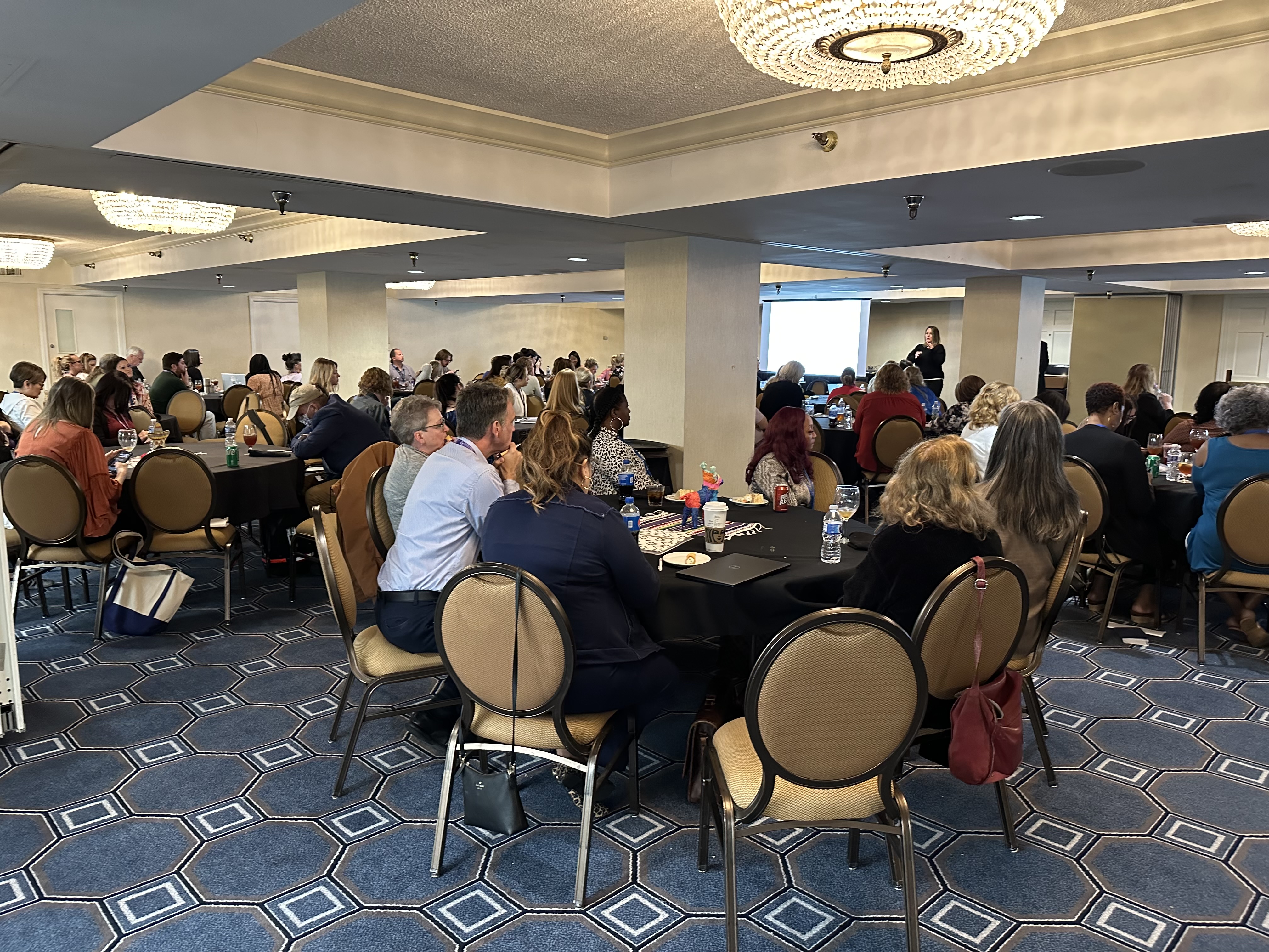 Photo of conference attendees attending the keynote speech. Crowded room