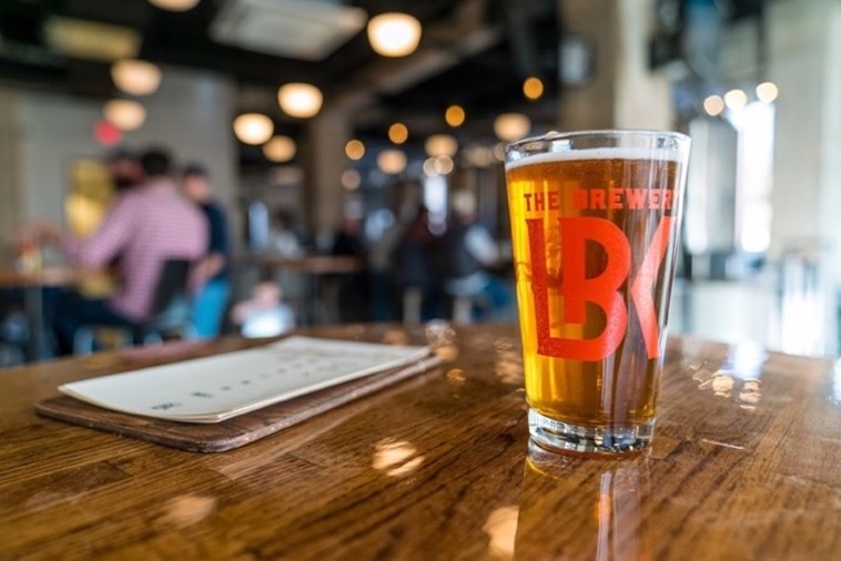 A glass of beer sits on a table.