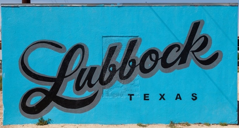 A mural with Lubbock, Texas in black font with a turquoise background.
